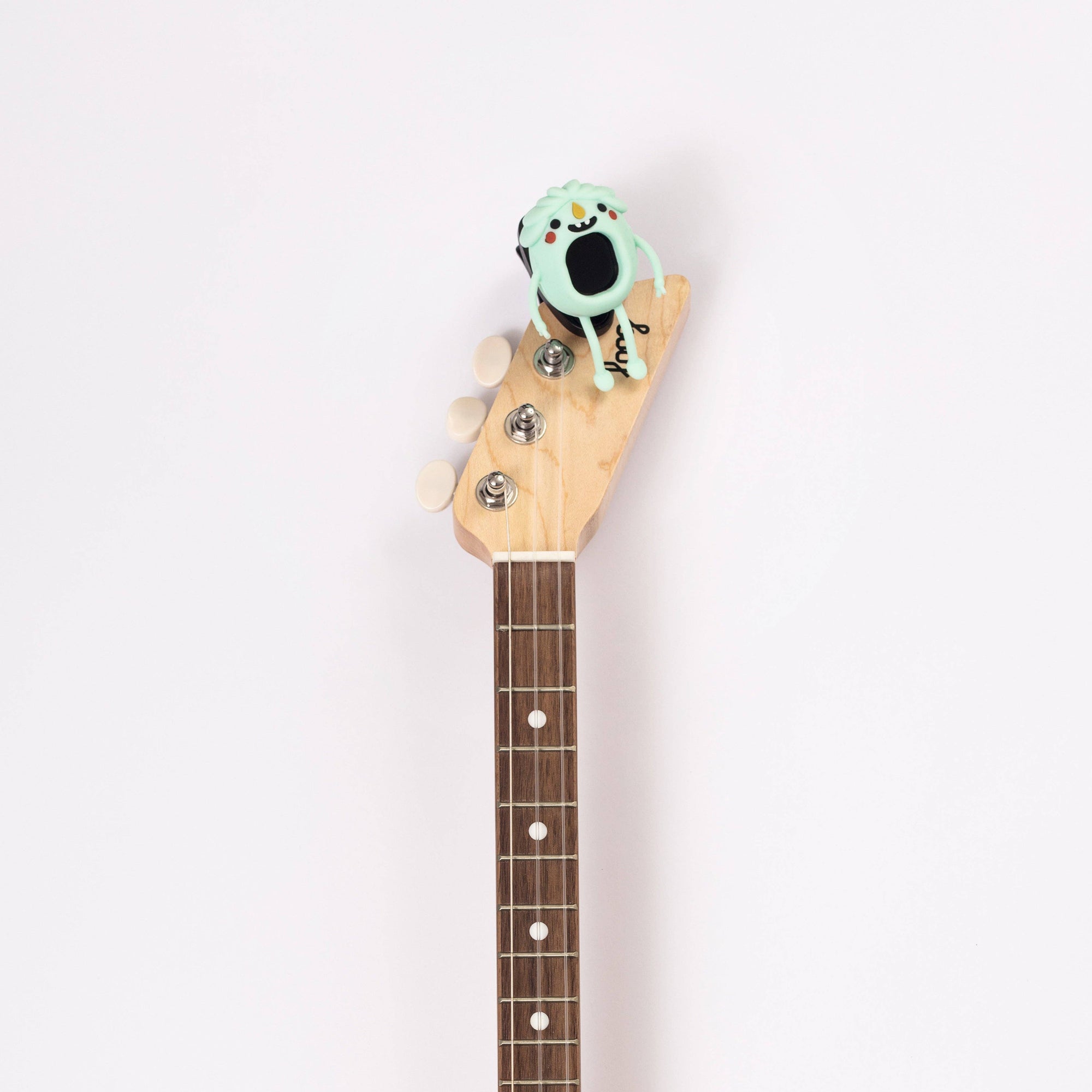 Guitar headstock with a decorative object on a white background