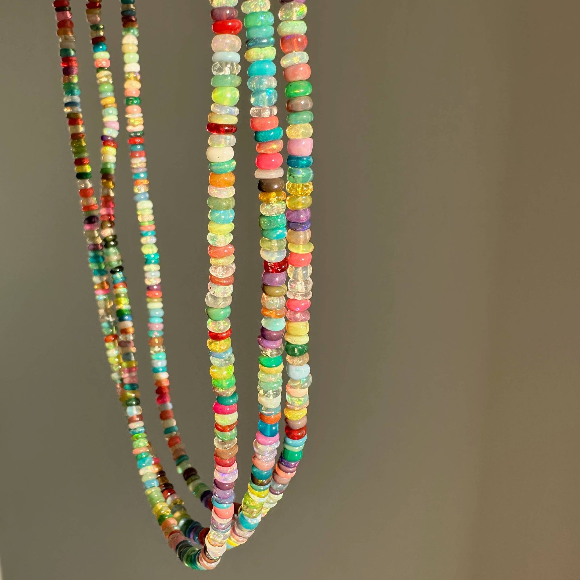 Three colorful beaded necklaces on a plain background