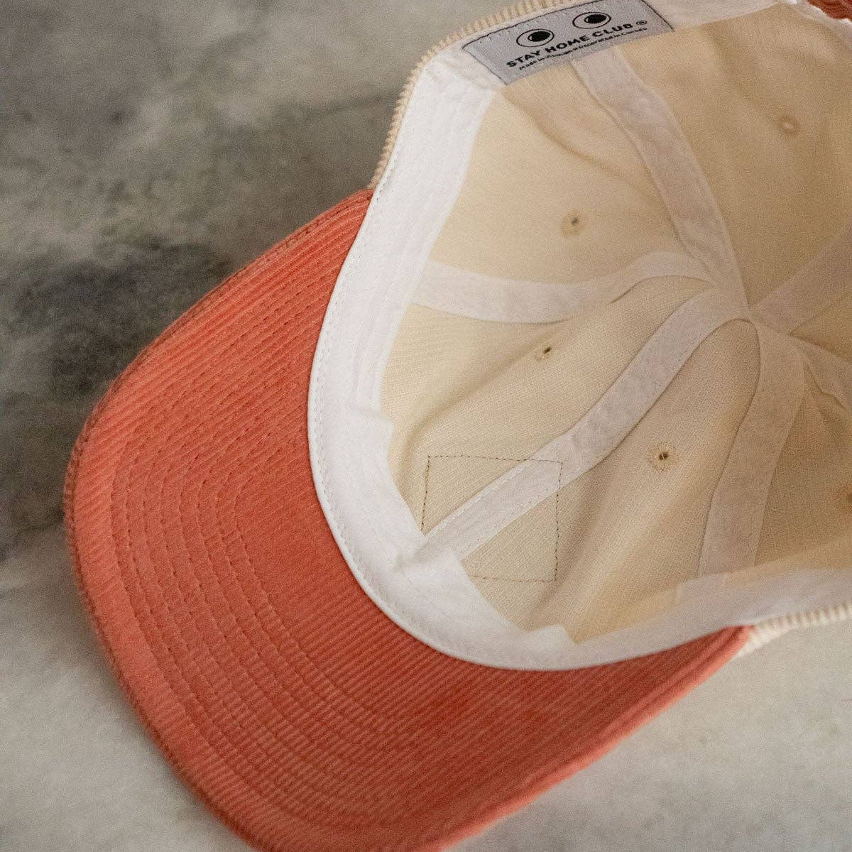 Orange cap with beige interior on a textured surface