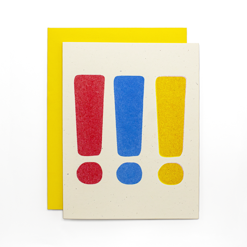 A square cream-colored card with three large exclamation marks in red, blue, and yellow, shown in front of a matching yellow envelope on a white background.