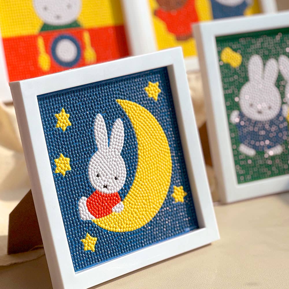 Cross-stitched bunny on a moon design with colorful background