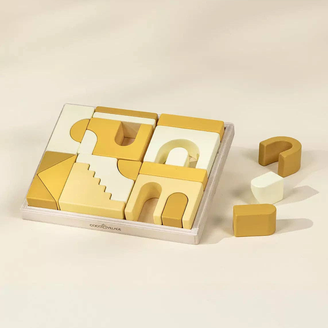 Set of wooden geometric shapes in a box on a beige background
