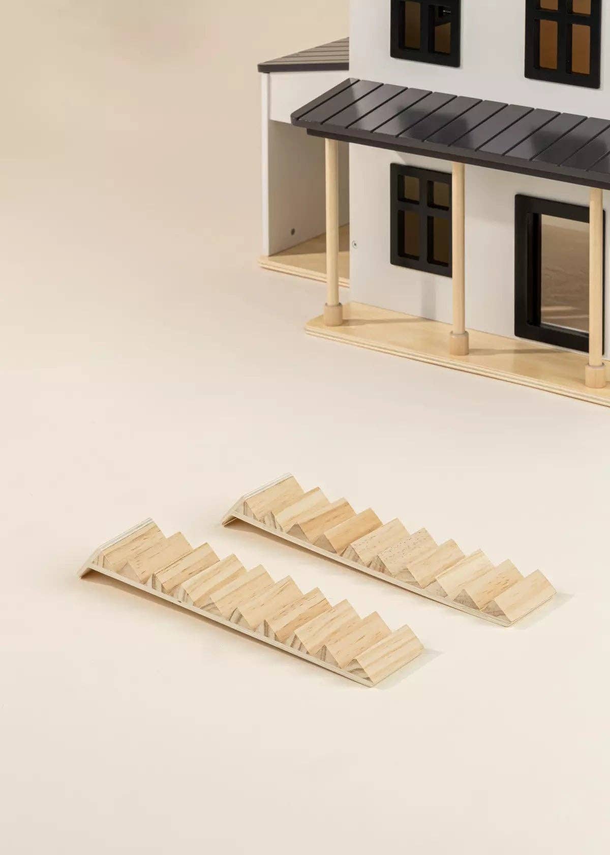 Wooden dollhouse with miniature furniture on a beige background