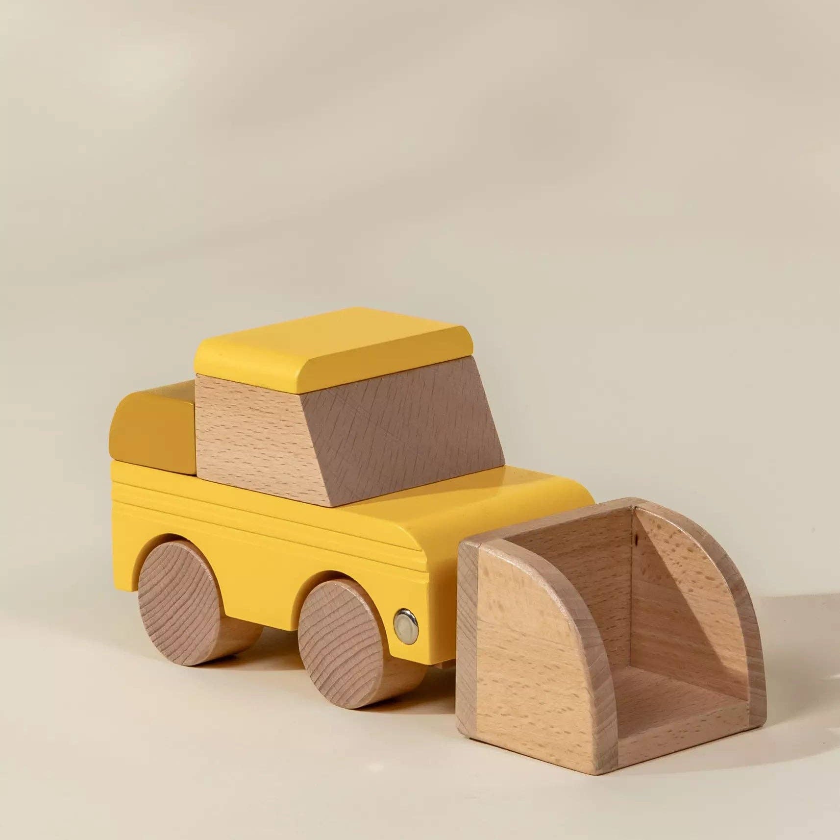 Yellow toy truck with a wooden front loader on a beige background