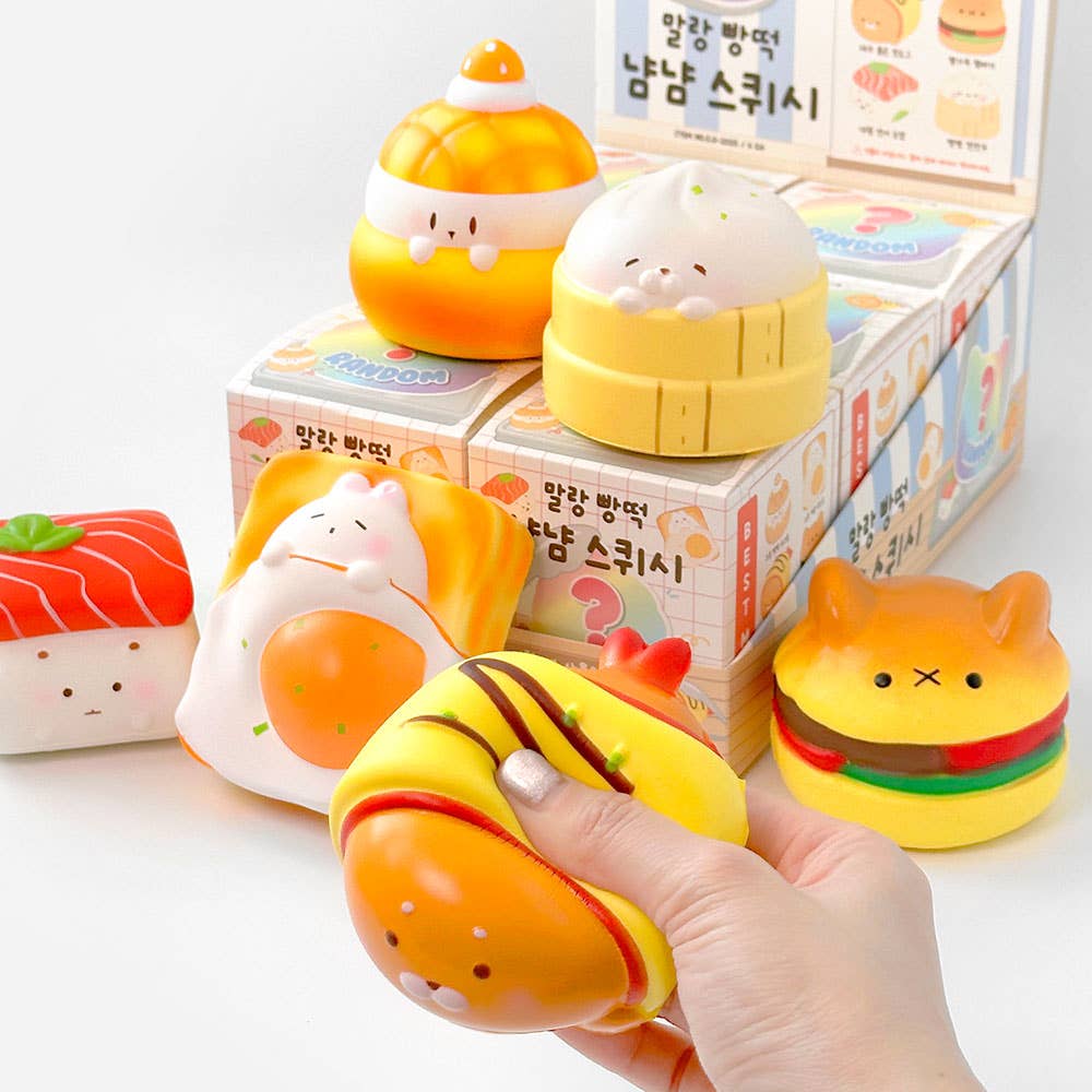 Set of cute food-themed squishies with a hand holding one, against a light background.