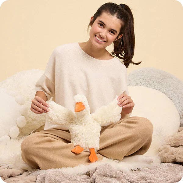 Woman holding a plush duck toy in a cozy setting