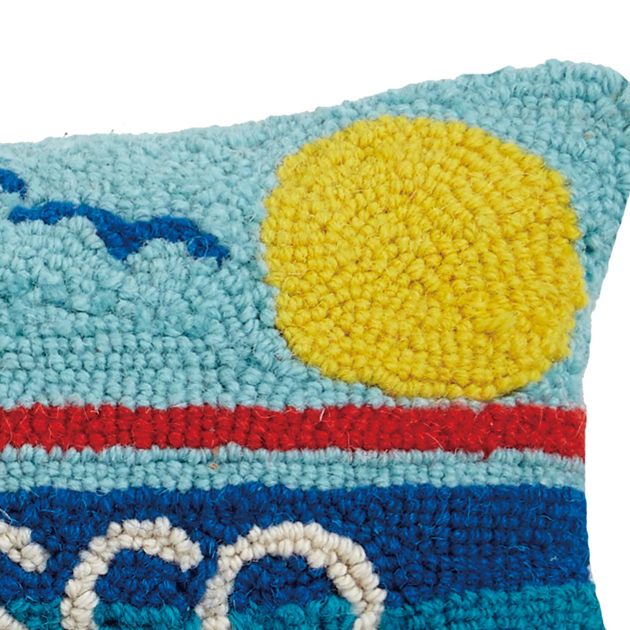 Textured pillow with a sun, clouds, and wave design on a white background