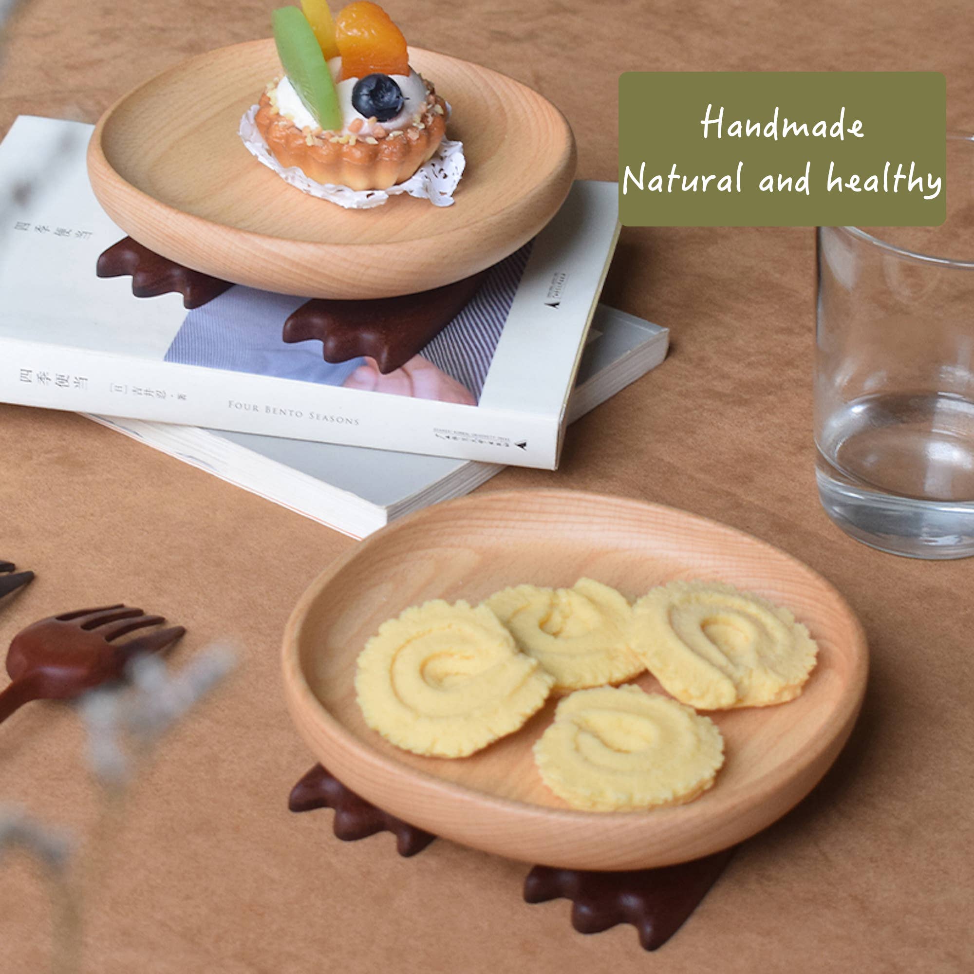 Wooden plate with cookies on a table with books and a glass of water.