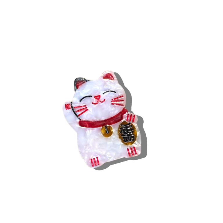 White cat-shaped brooch with red accents on a white background