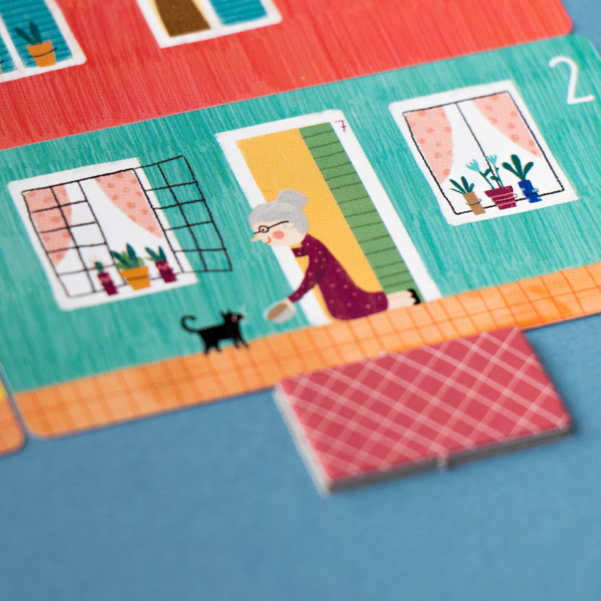 Colorful board game piece with a character and cat on a blue background