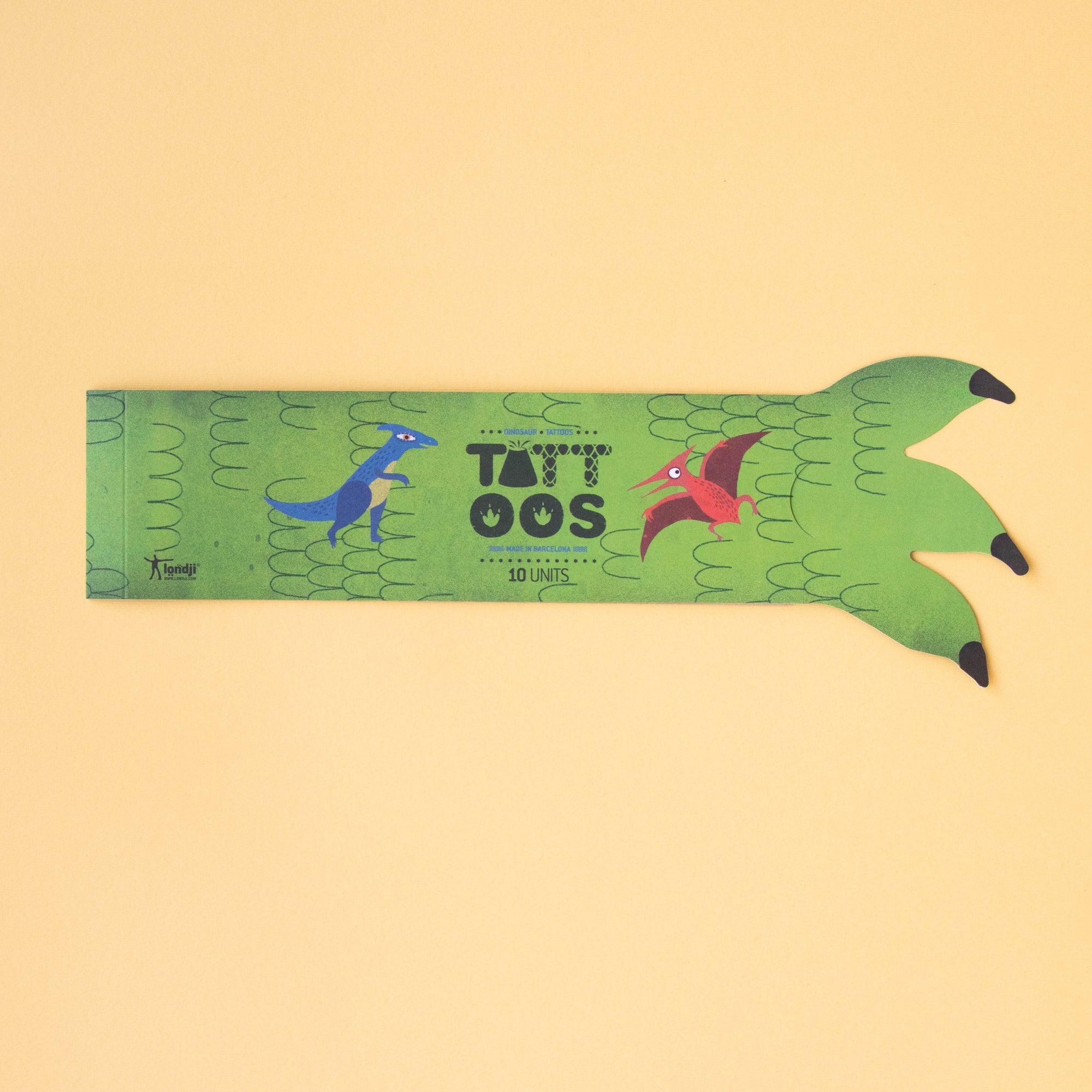 Green dinosaur-shaped tattoo book with 'TattOos' branding on a beige background