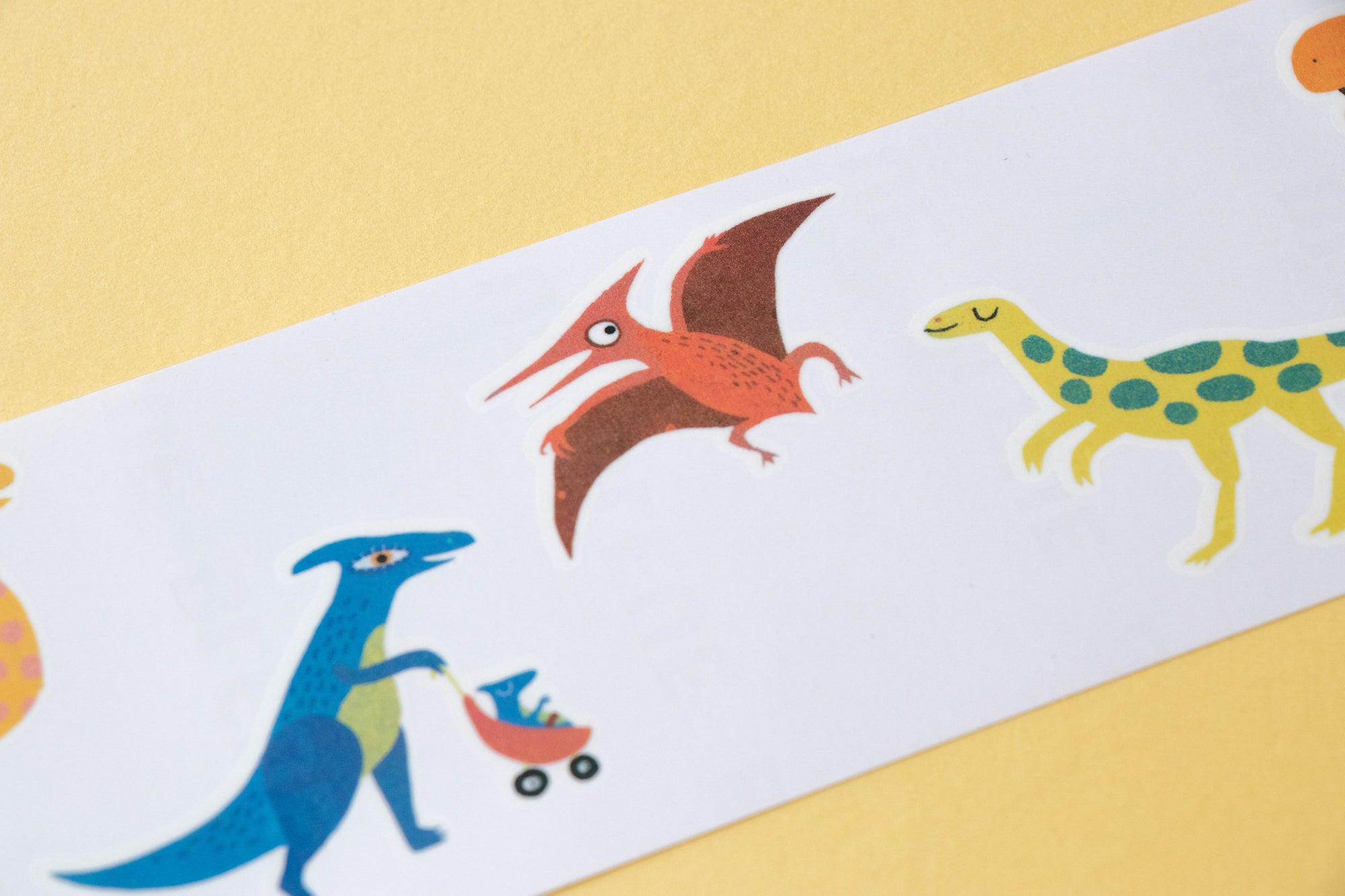 Colorful dinosaur illustrations on a white background with a yellow border.