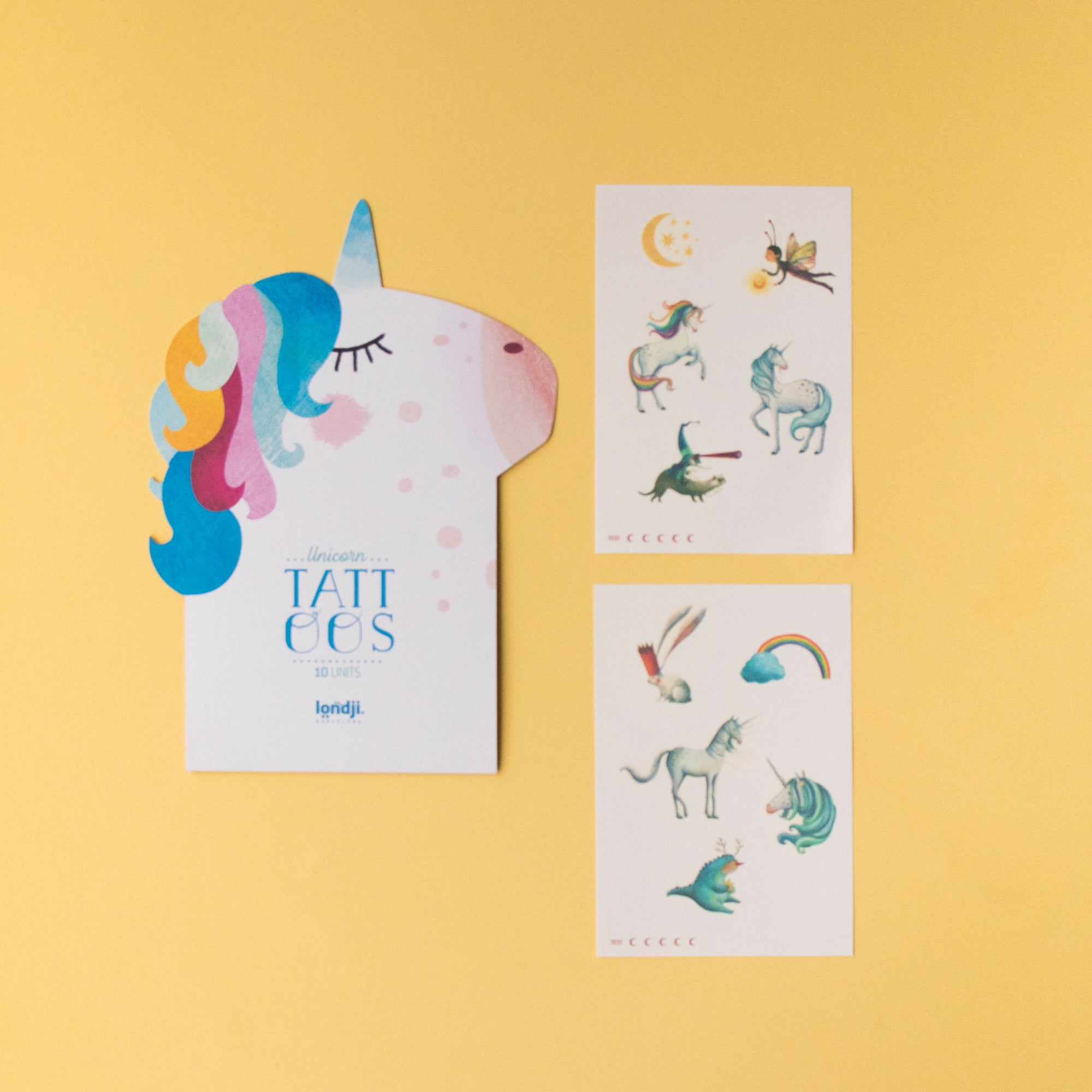 Unicorn-shaped card with 'TATtoo's' and two sheets of unicorn-themed tattoos on a yellow background