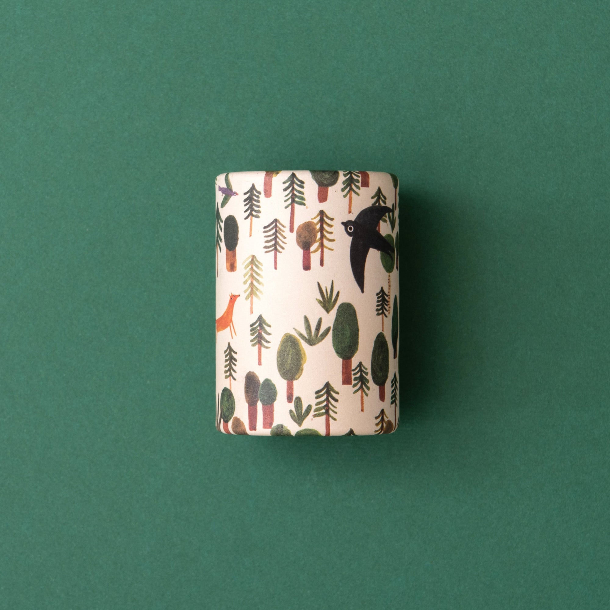 Small cylindrical Kaleidoscope with forest pattern on a green background