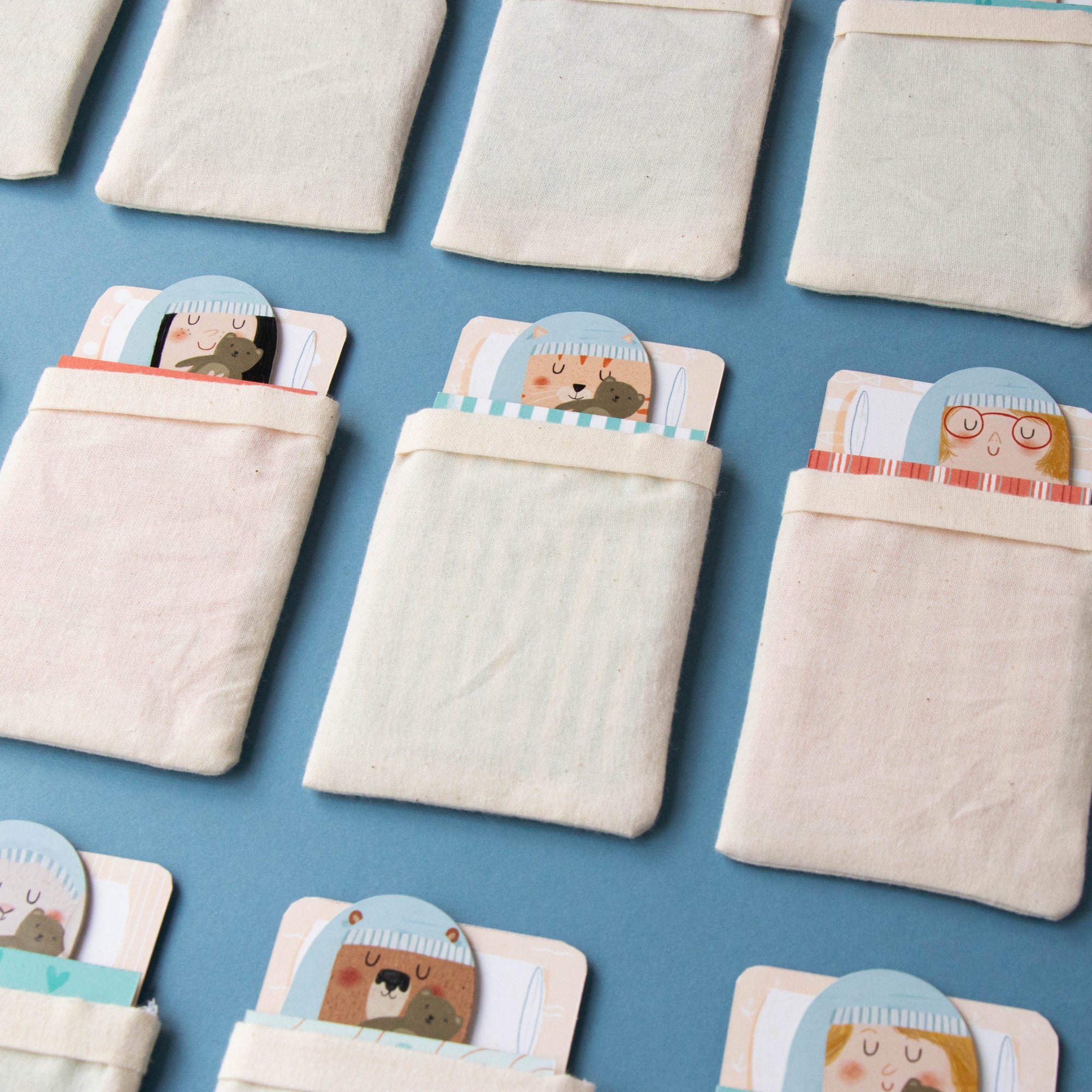 Small fabric bags with cartoon bear faces on a blue background