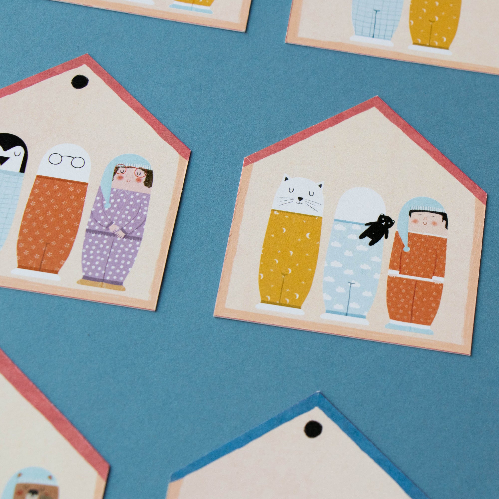 Small house-shaped cards with cartoon characters on a blue background