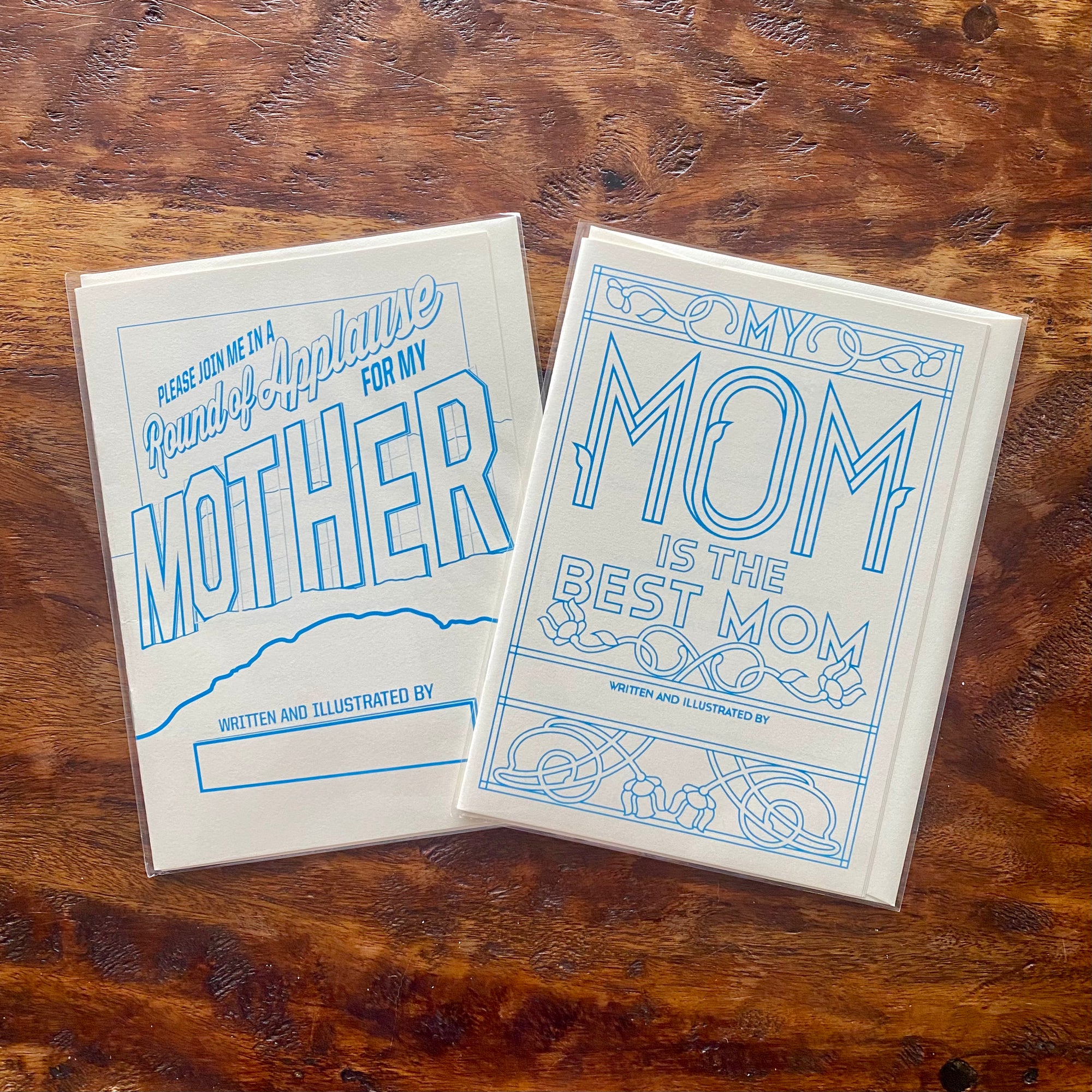 Two greeting cards with blue text on a wooden surface
