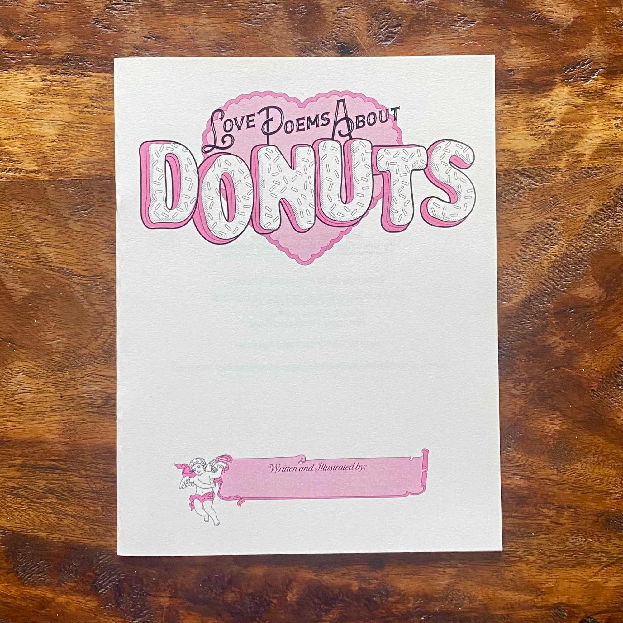 Book titled 'Love Poems About Donuts' on a wooden surface