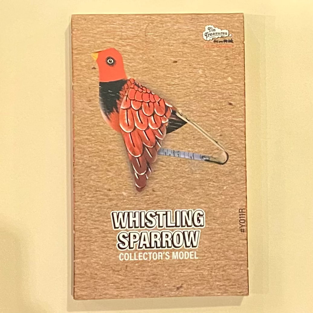 Wooden box with a whistling sparrow design on a wooden surface