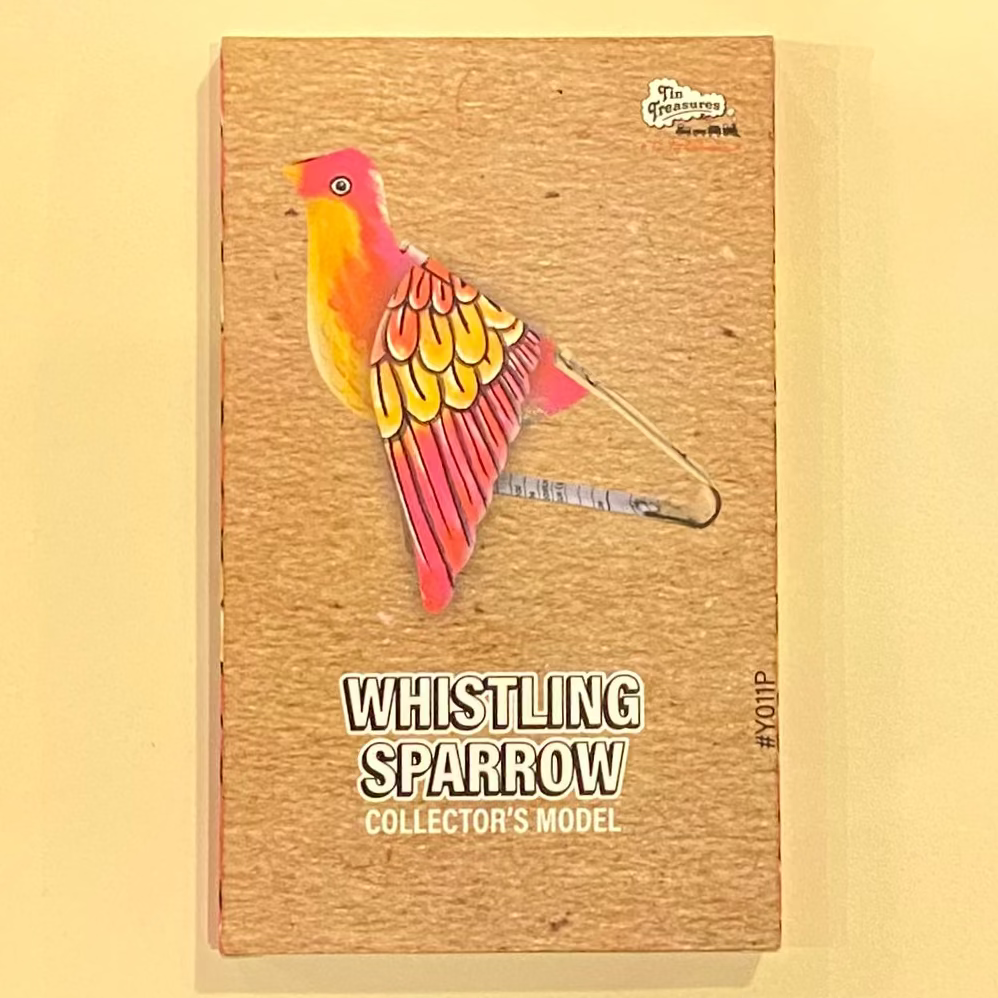 box with a colorful bird illustration and text on a wooden surface