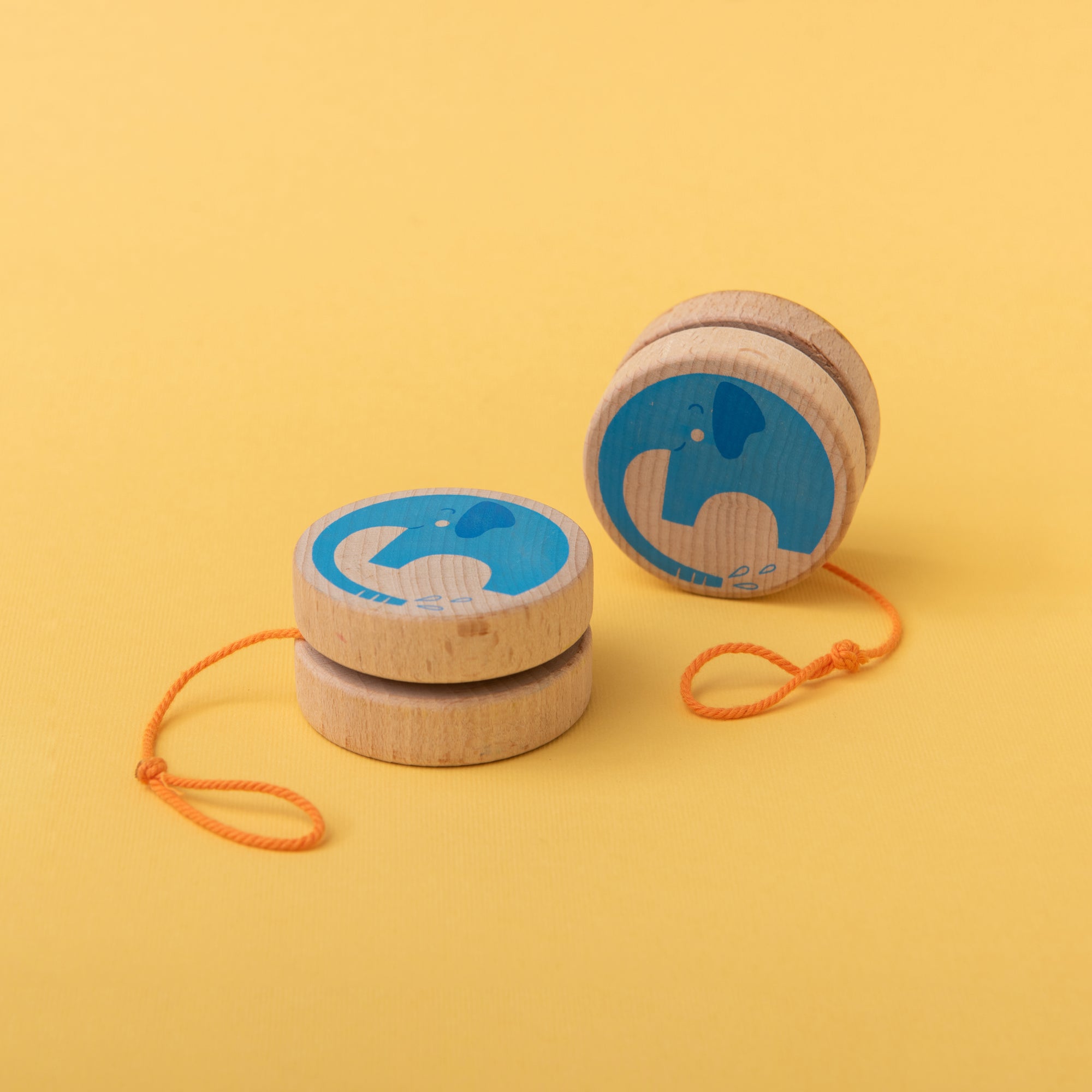 Wooden yoyo's with blue designs on a yellow background