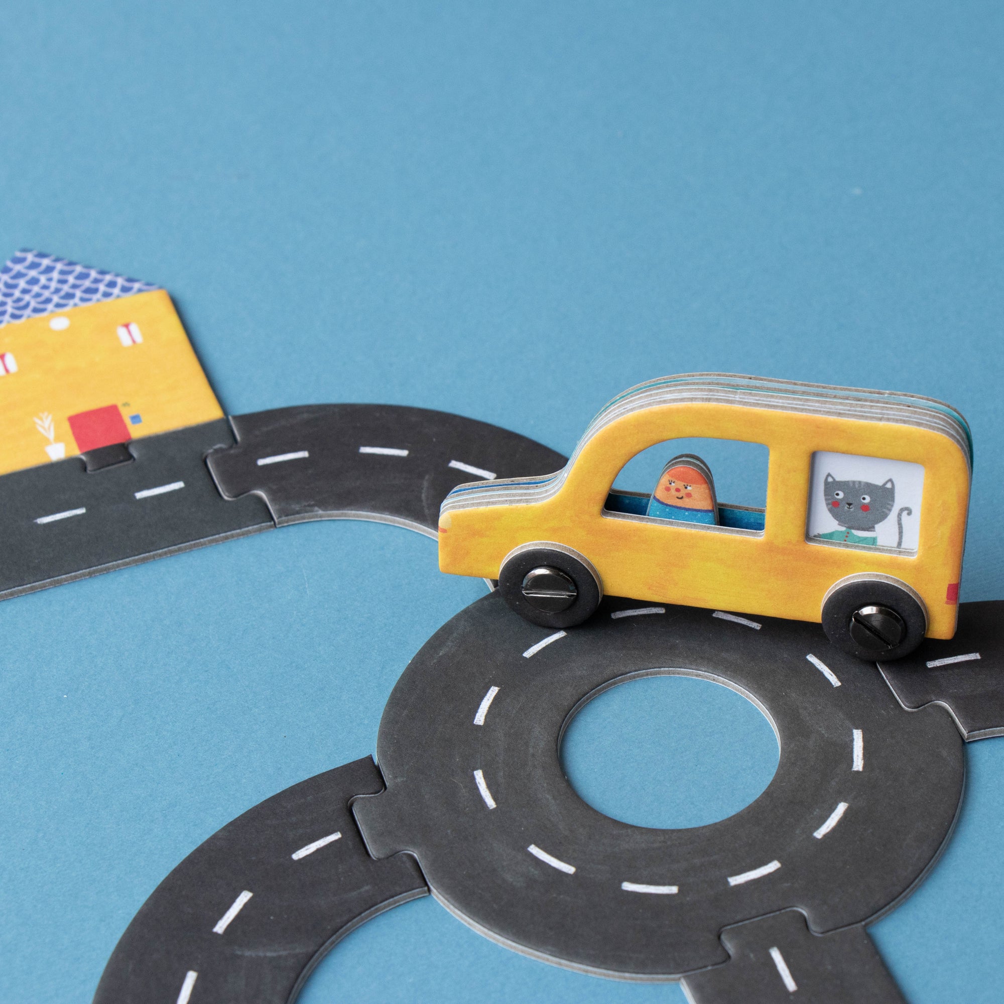 Toy car on a paper road with a blue background