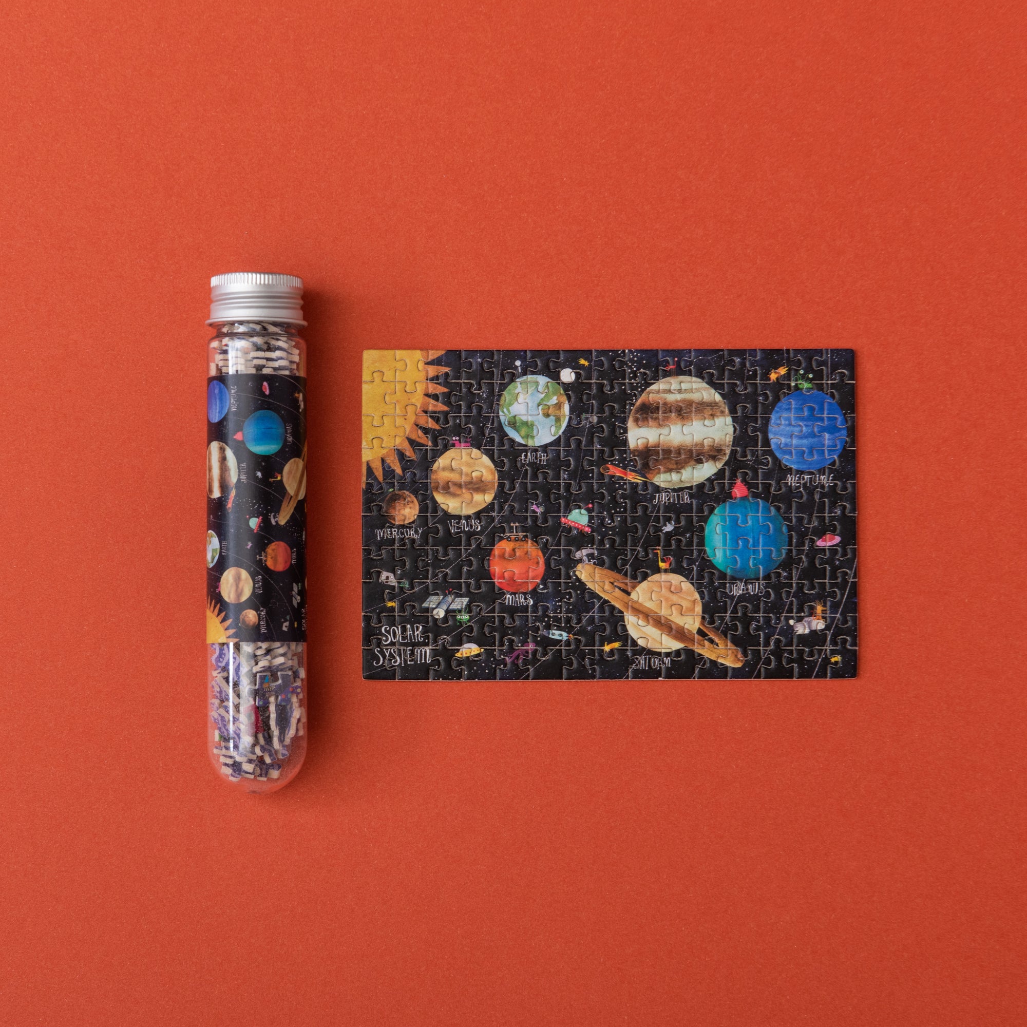 Solar system-themed puzzle and packaging on an orange background