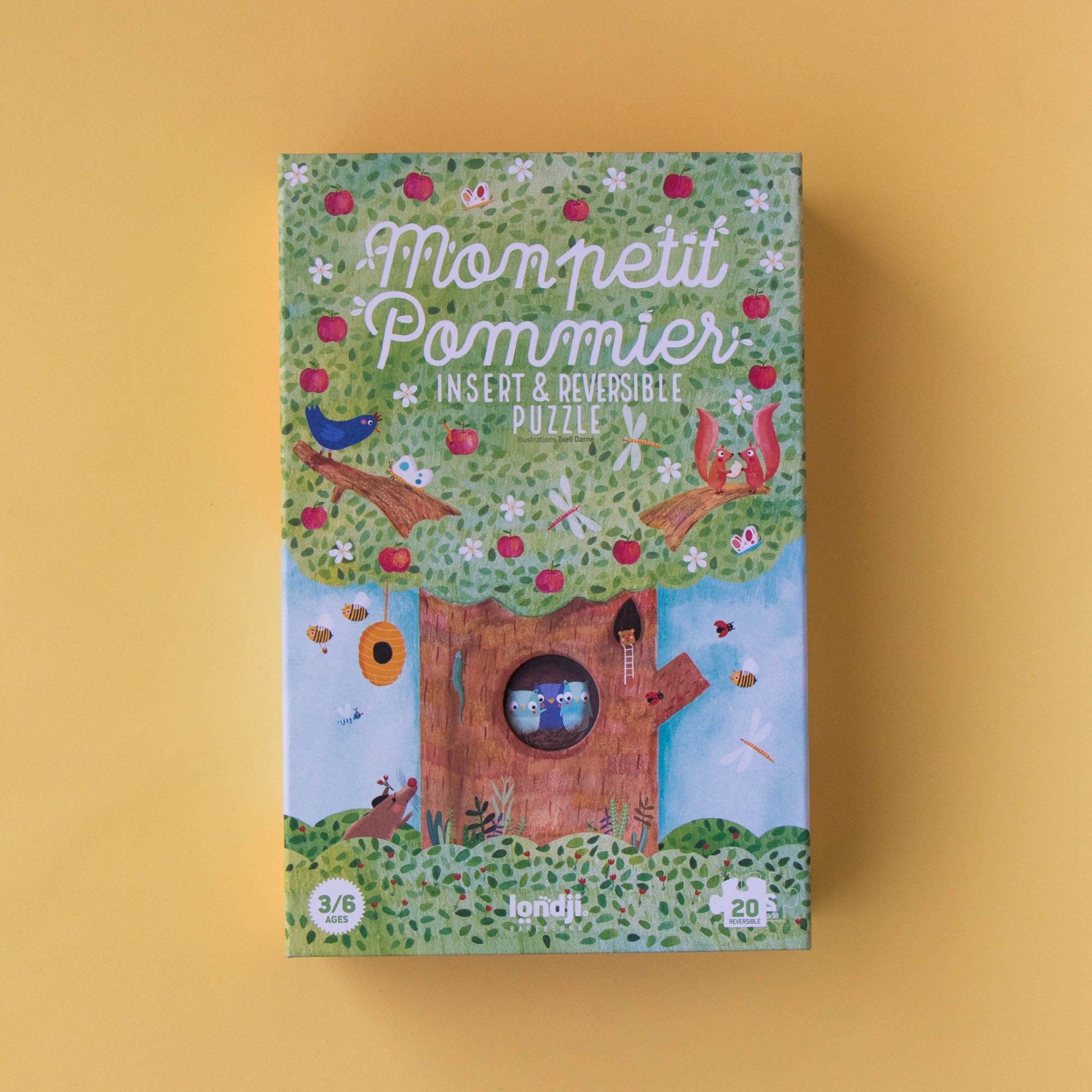Children's book titled 'Mon Petit Pomme' with a colorful cover featuring a treehouse and animals on a yellow background.