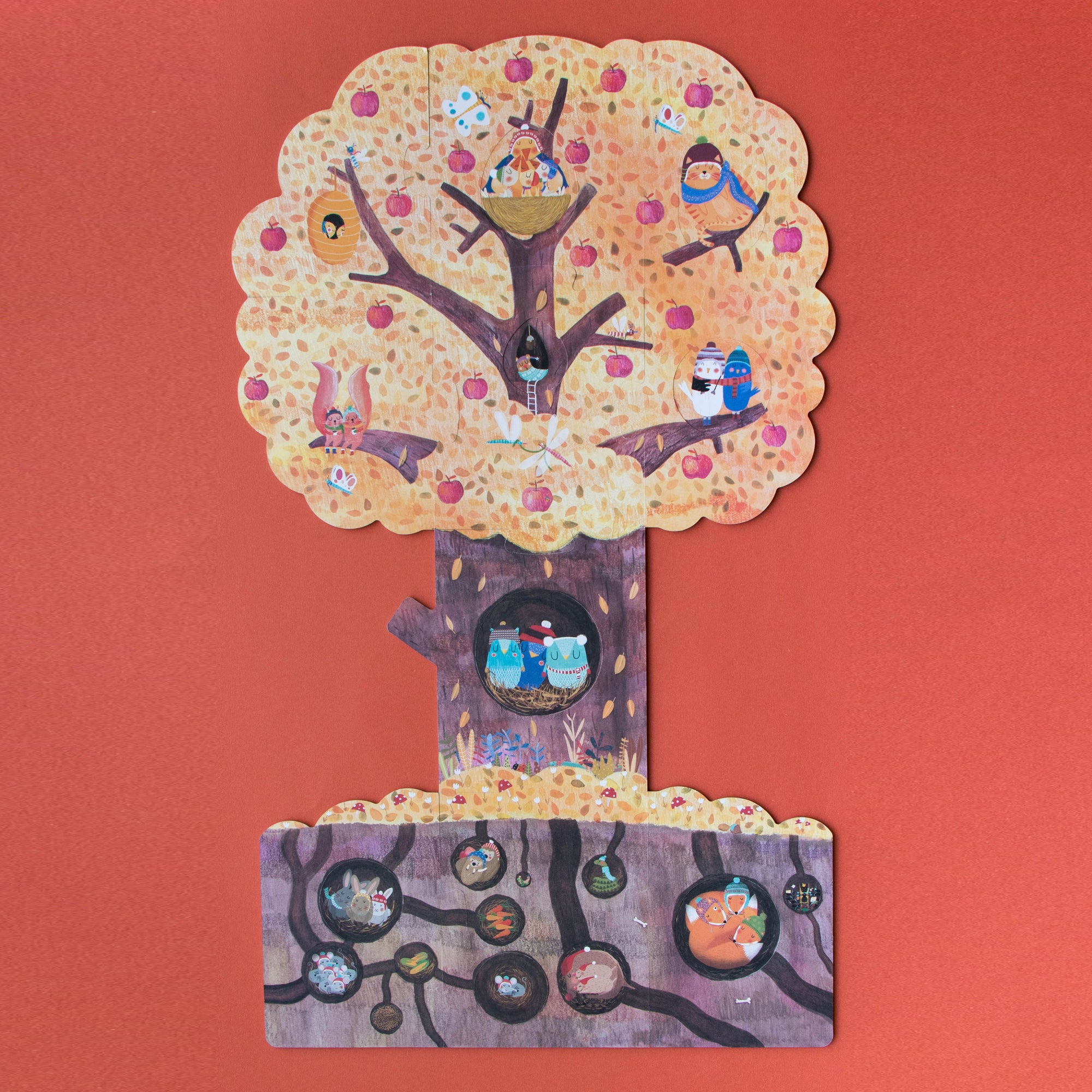 Tree-shaped object with various small figures on a red background