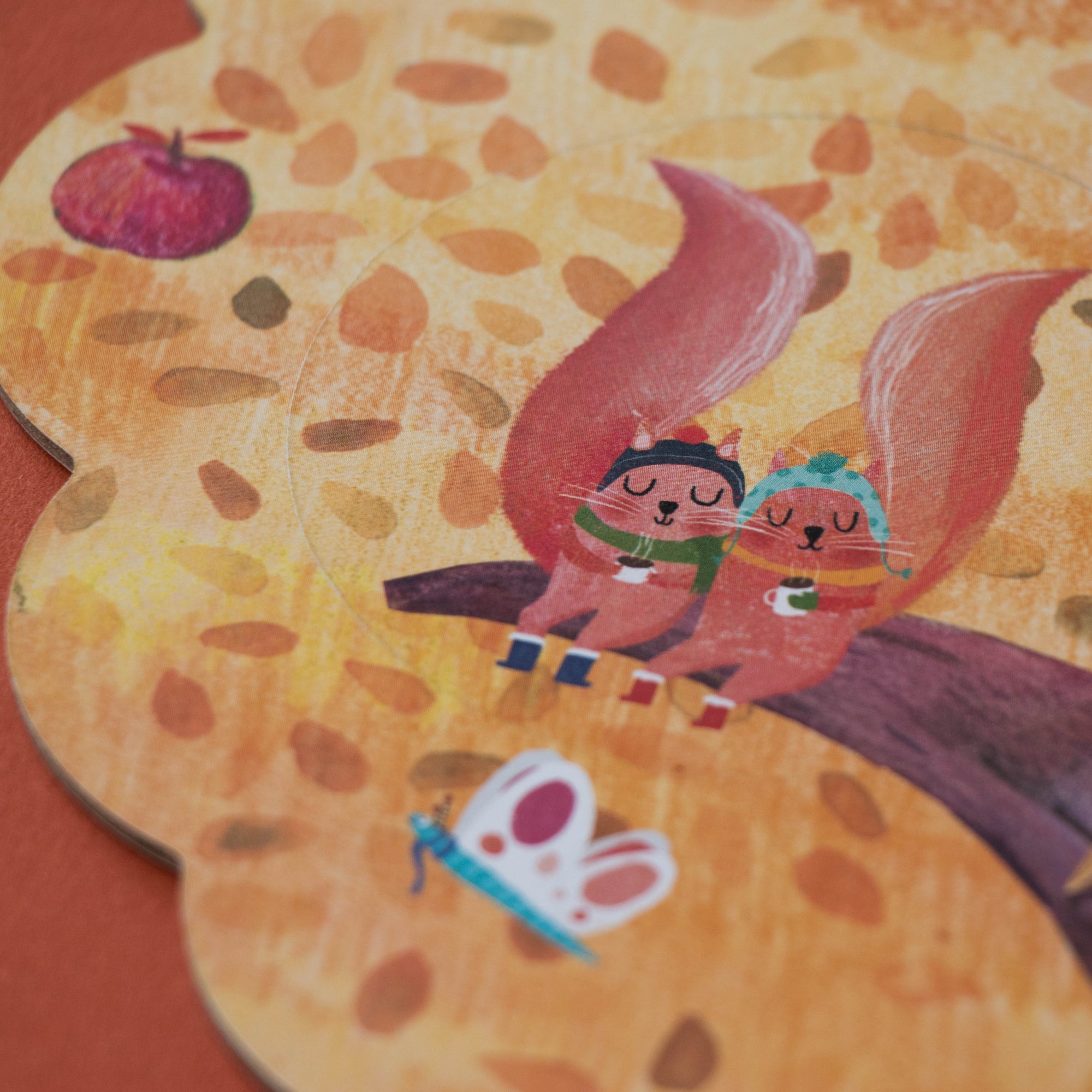 Illustration of two foxes sitting on a log with autumn leaves in the background