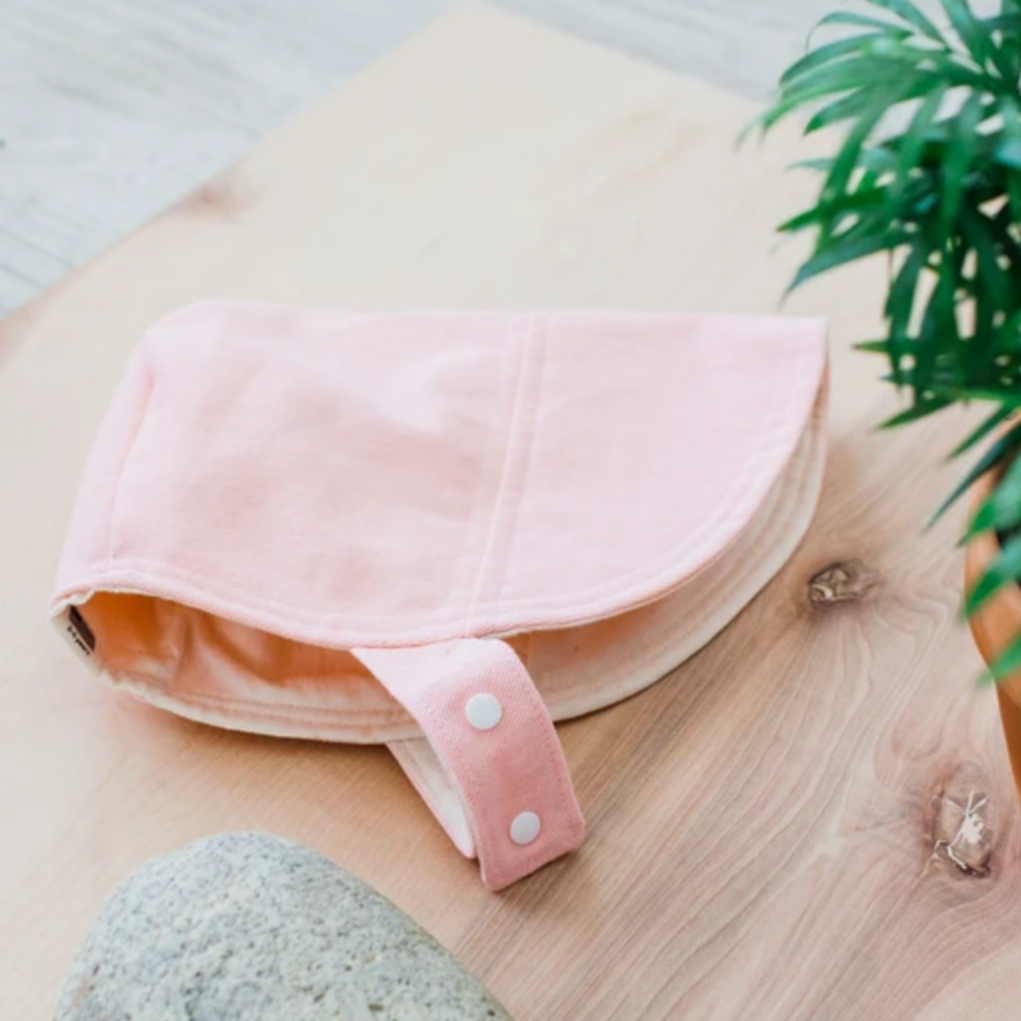 pink sun bonnet with plant and rock