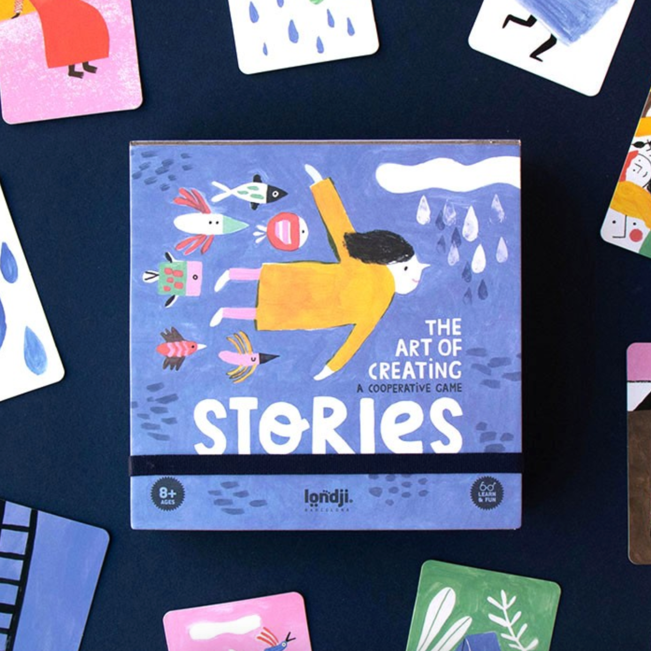 A game box and assorted game cards featuring colorful illustrations of various body parts and elements, with the title 'The Art of Creating Stories'.