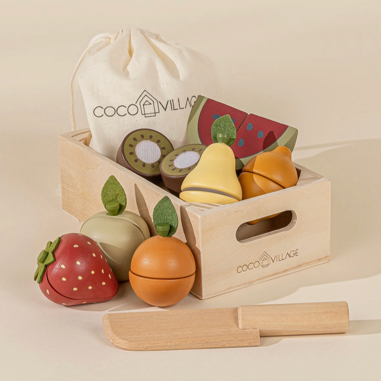 A wooden basket filled with various colorful fruits and a wooden knife, branded with 'COCO VILLAGE'.
