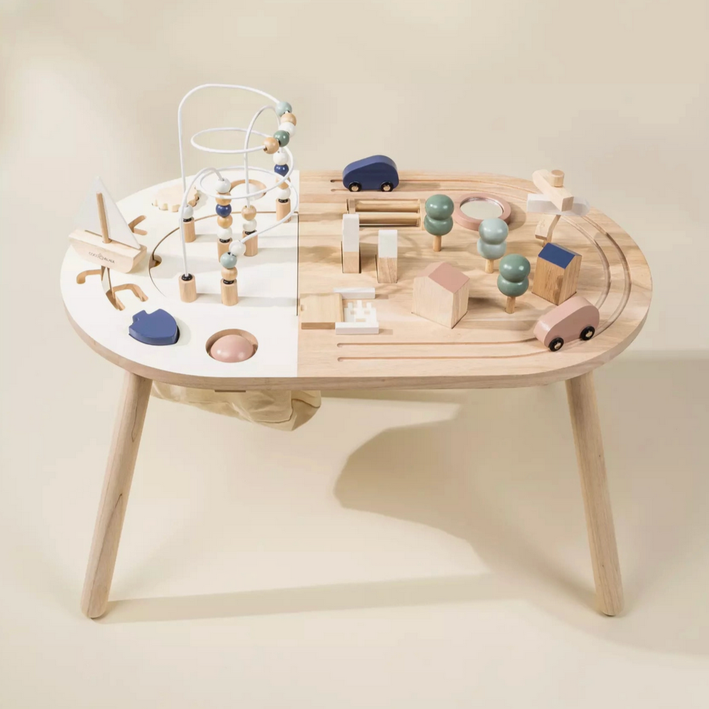 A wooden activity table for toddlers with various toys and a ball maze setup on it.
