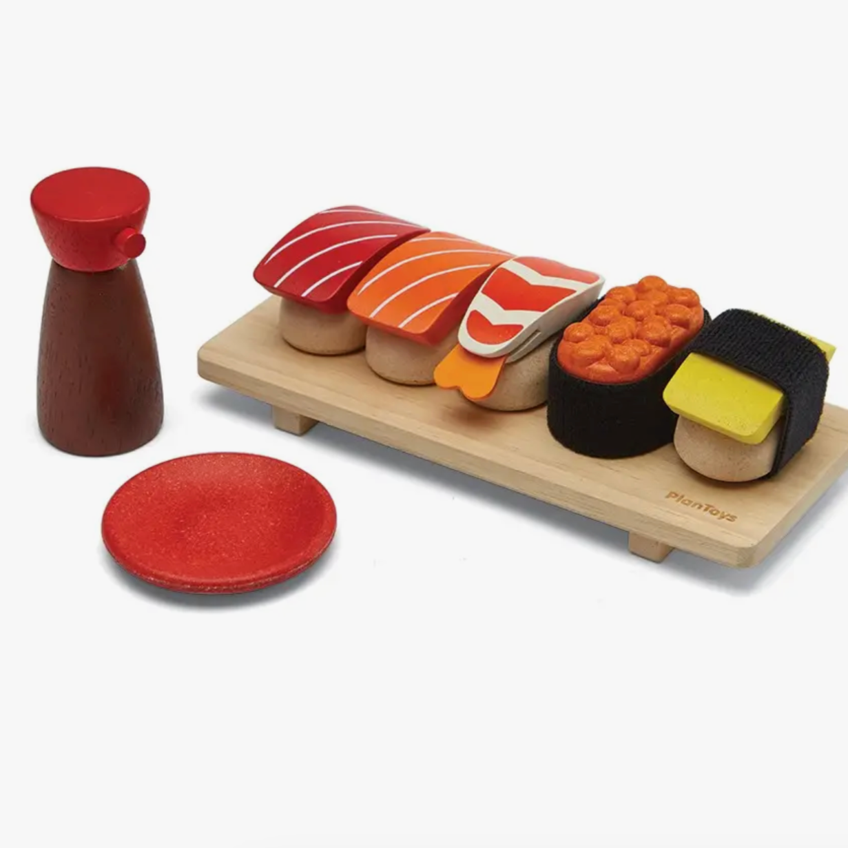 A wooden sushi set including various colorful plastic sushi pieces, a shoyu bottle, a sauce dish, and a sushi tray.
