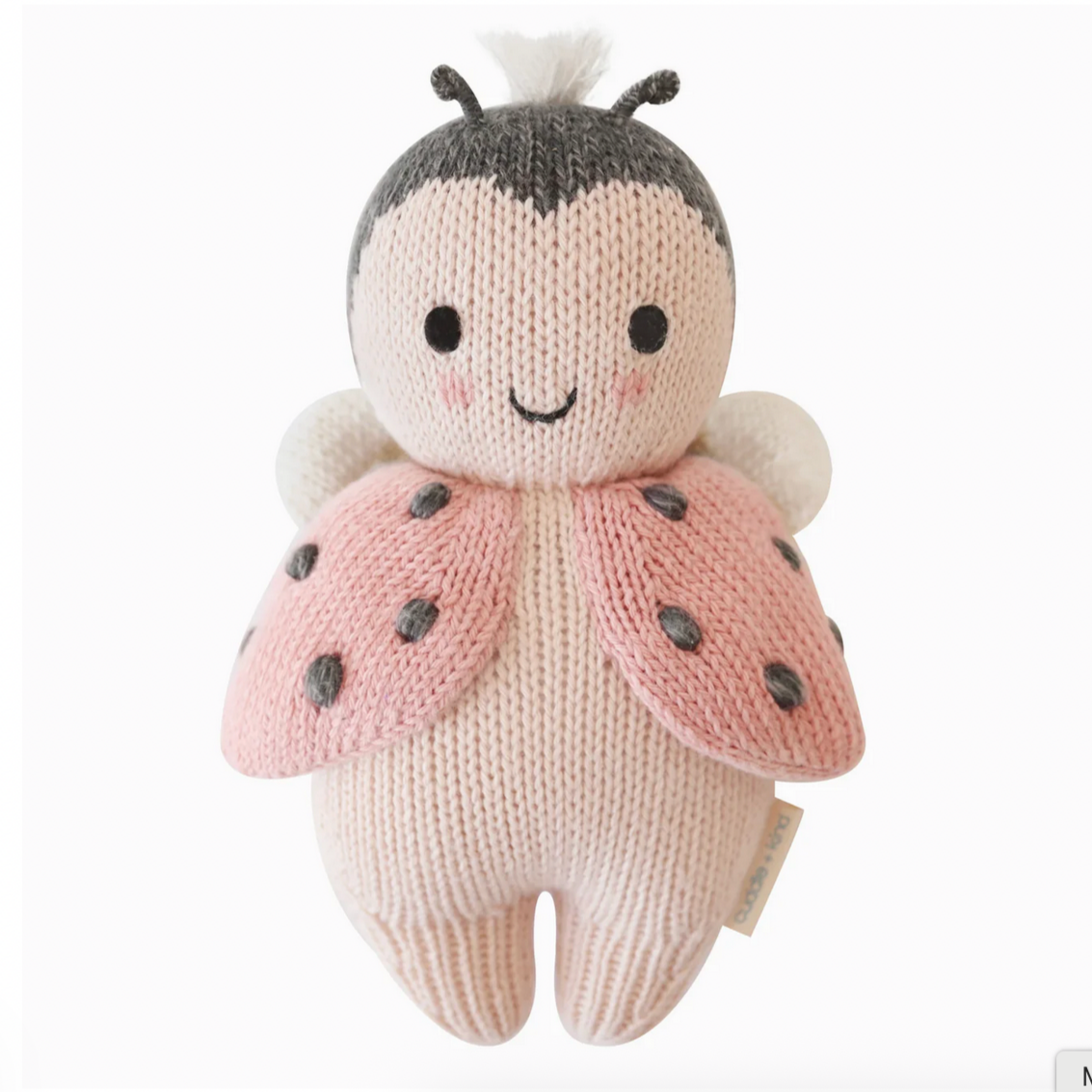 Knitted toy ladybug with pink wings and black spots on a white background