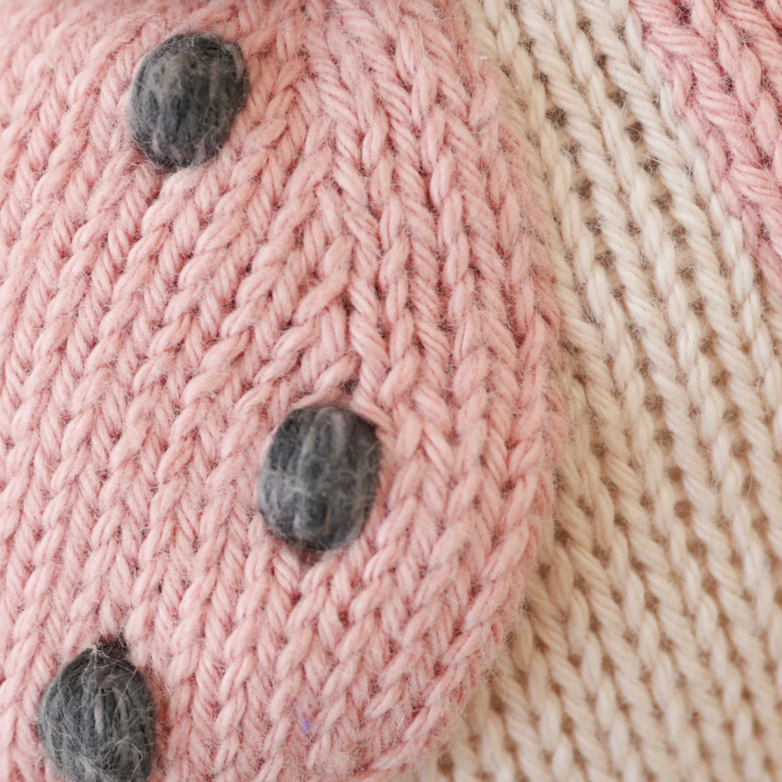 Close-up of pink knitted fabric with gray buttons