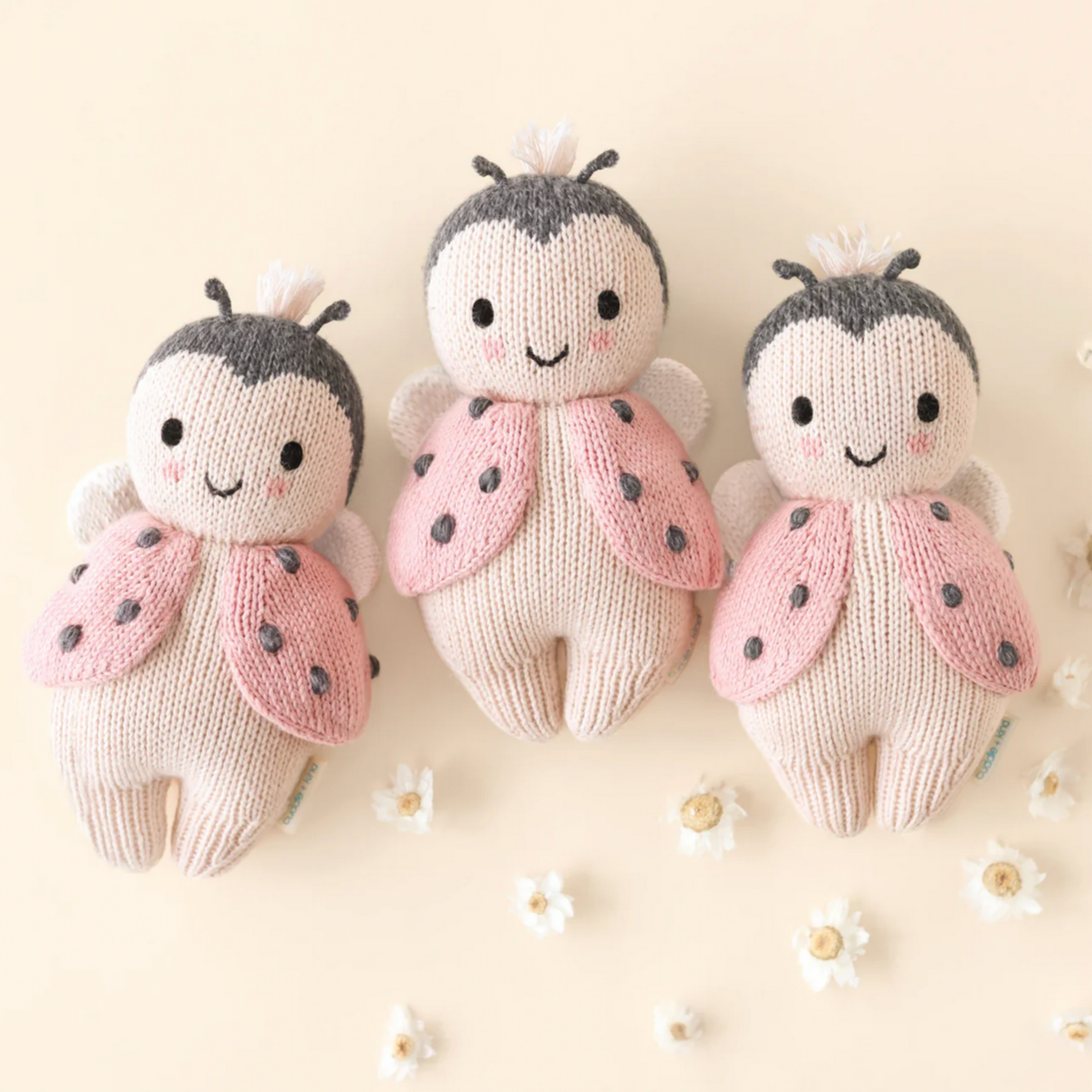 Three knitted ladybug toys on a light background
