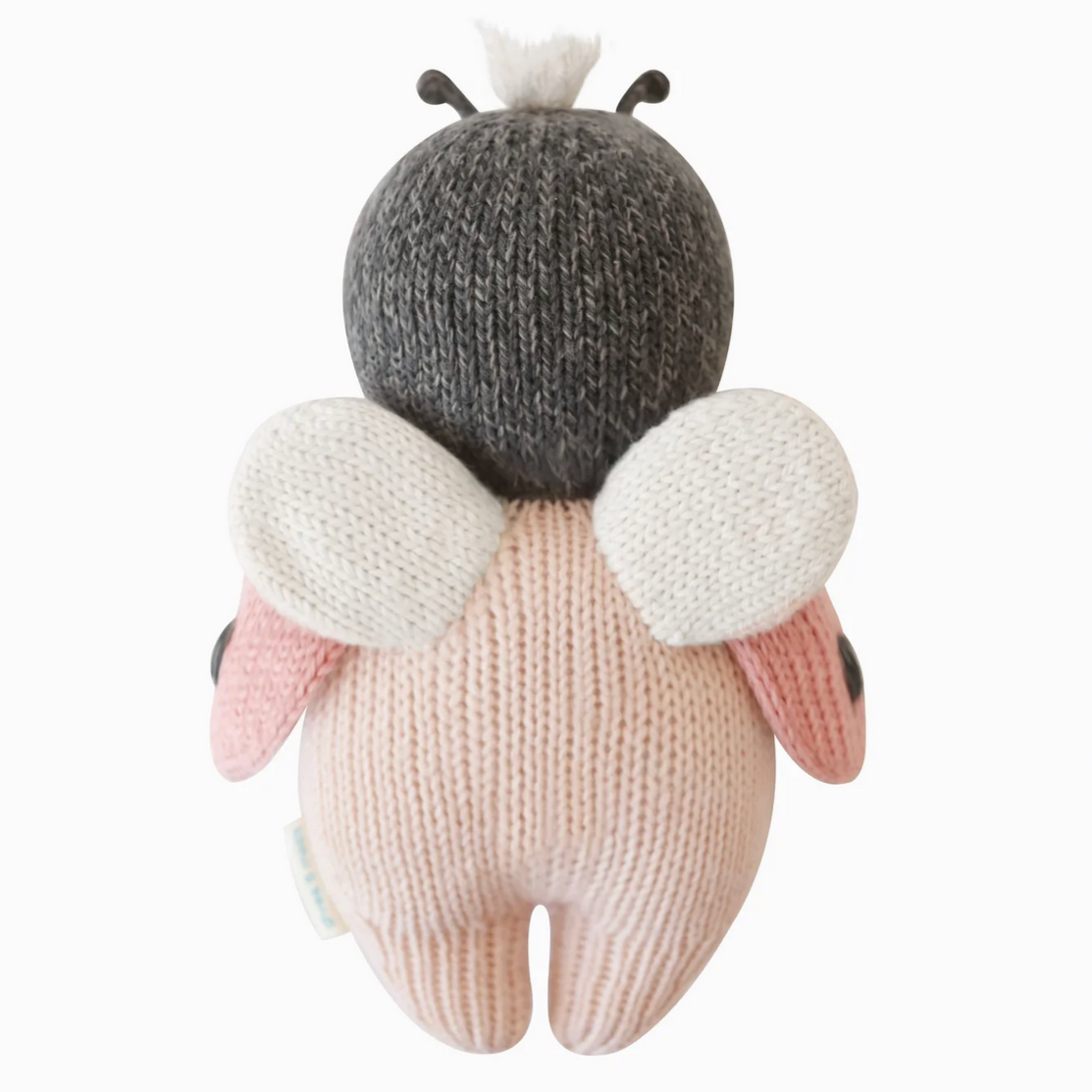 Knitted toy resembling a ladybug with a gray head, white wings, and pink body on a white background