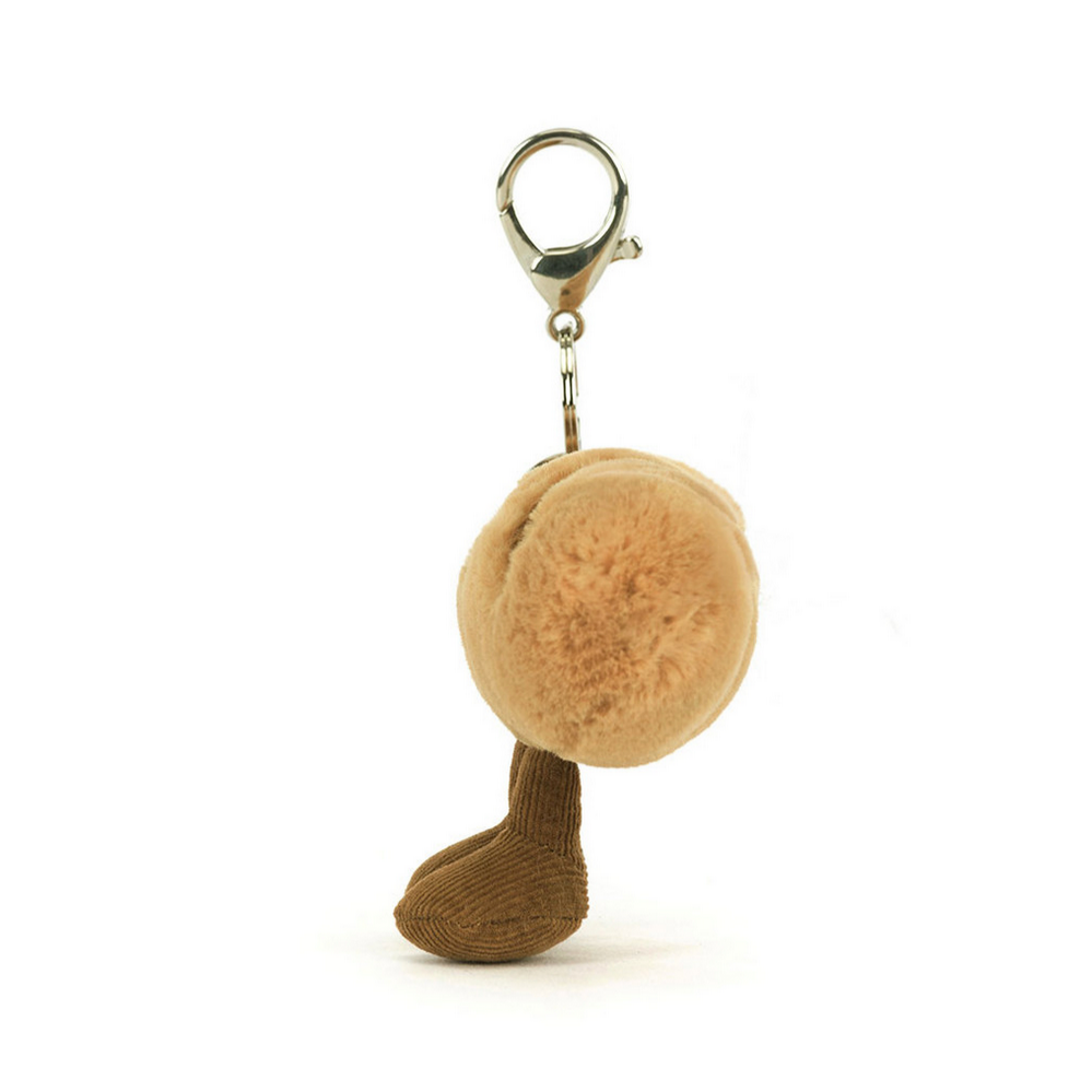 Plush keychain with a round beige ball and brown sock on a white background