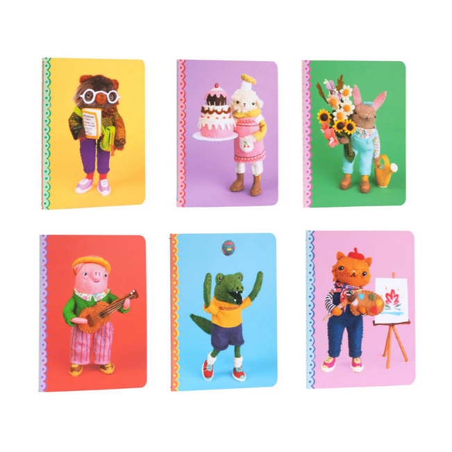 Set of colorful notebooks with felted character designs on a white background