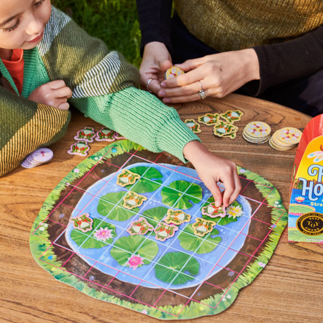Children playing with a board game on a wooden table