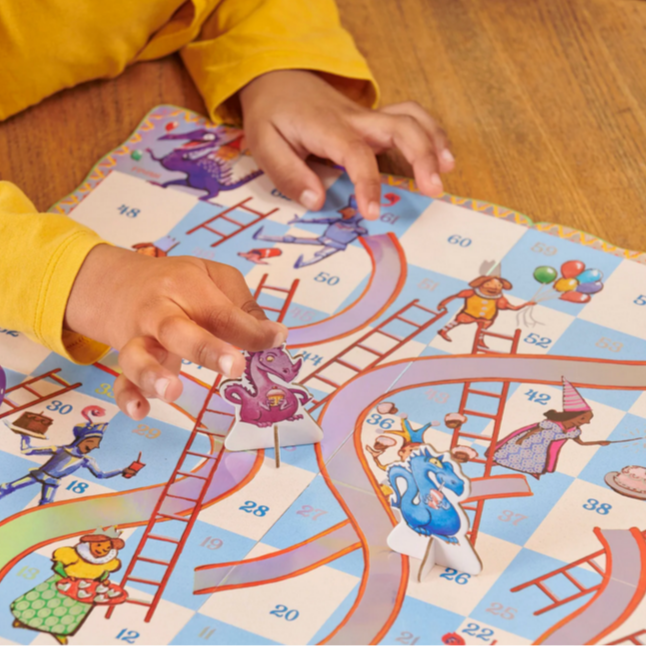 Child playing with a colorful board game on a wooden floor