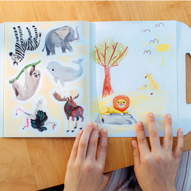 Children's sticker book with animal illustrations on a wooden table