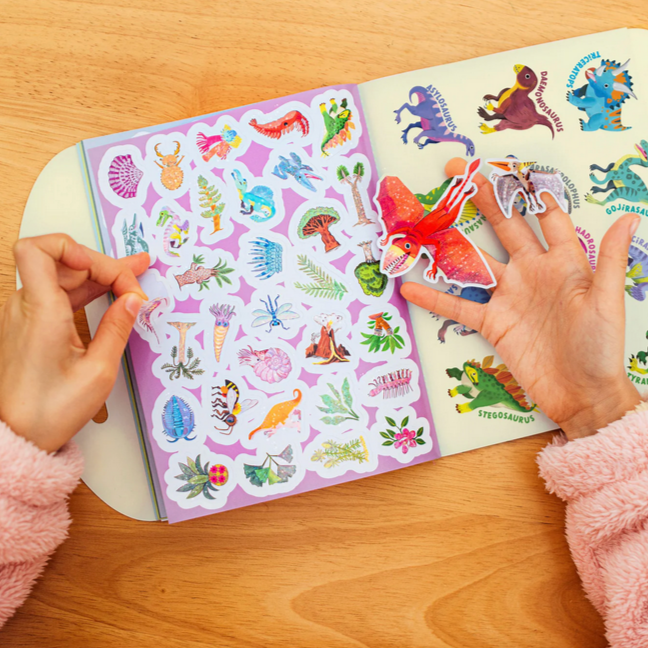 Sticker book with colorful stickers on a wooden surface