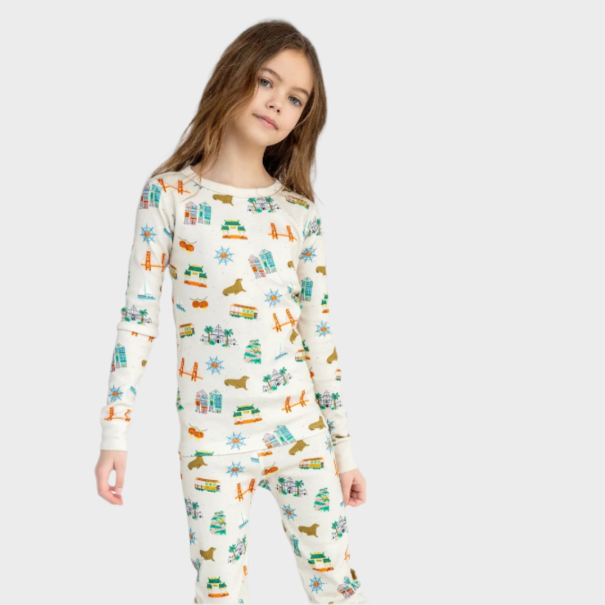 Child wearing a patterned onesie on a white background