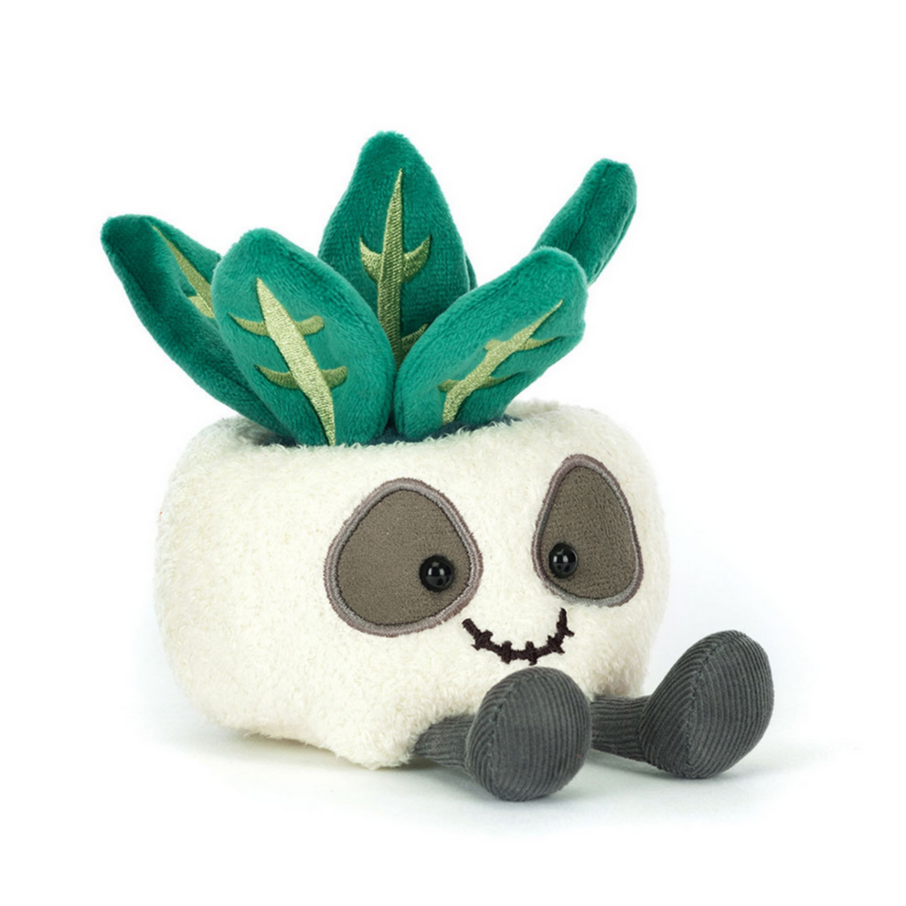 Plush skull planter with green leaves on a white background