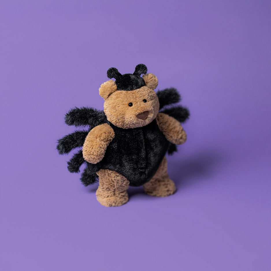 Plush toy bear dressed as a spider on a purple background