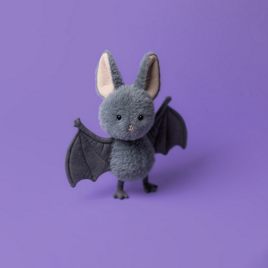 Stuffed bat toy on a purple background