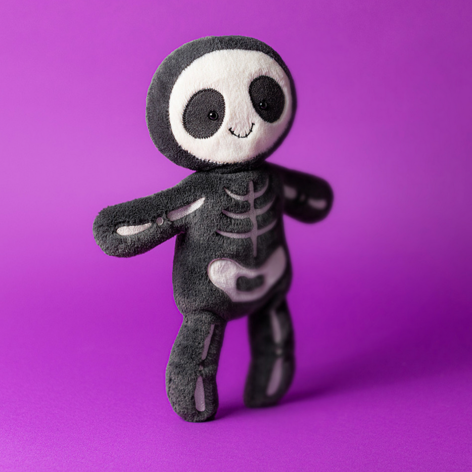 Skeleton plush toy on a purple background